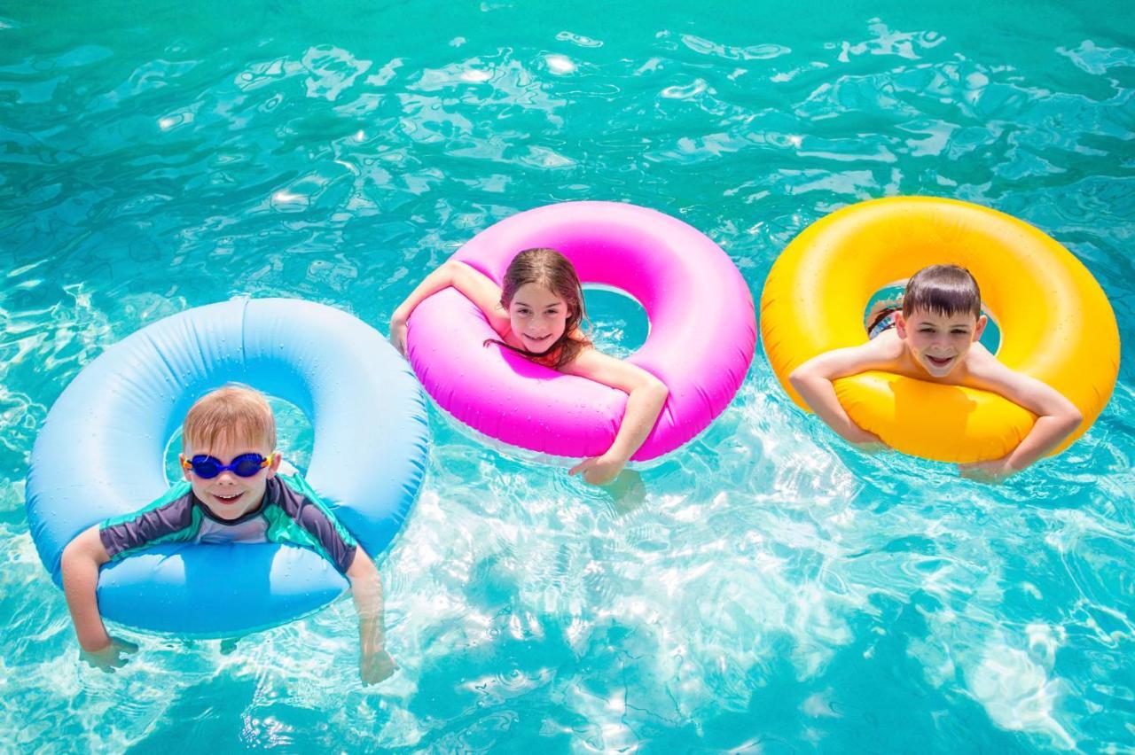 فندق إيه سي تي الشارقة المظهر الخارجي الصورة Children using inner tubes in a swimming pool